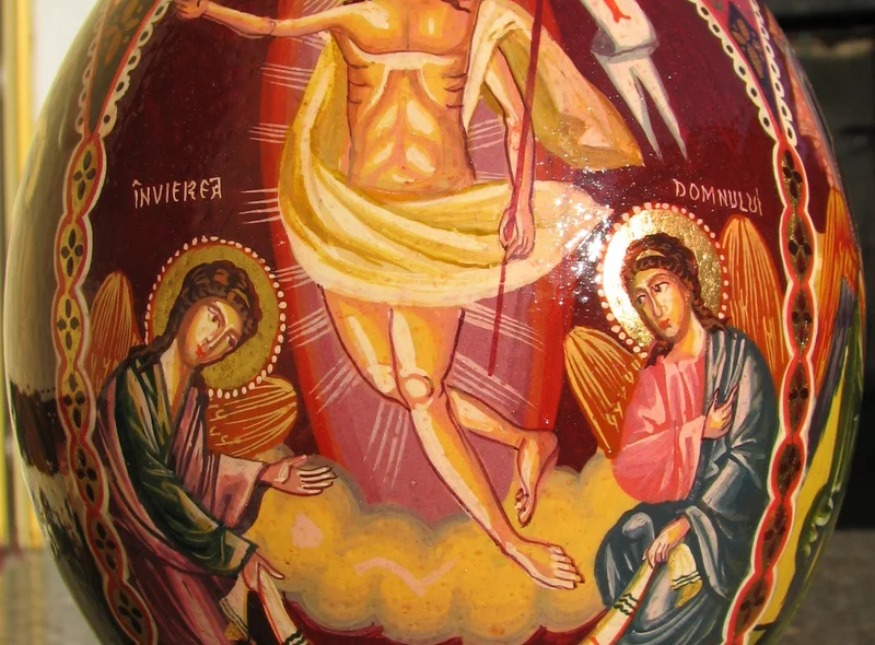 Ein kunstvoll mit Abbildungen von Jesus Christus und zwei Heiligen bemaltes Osterei