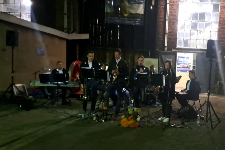 Ein Ensemble junger Jazzmusikerinnen und -musiker geben in einem historischen Lokschuppen ein Konzert.