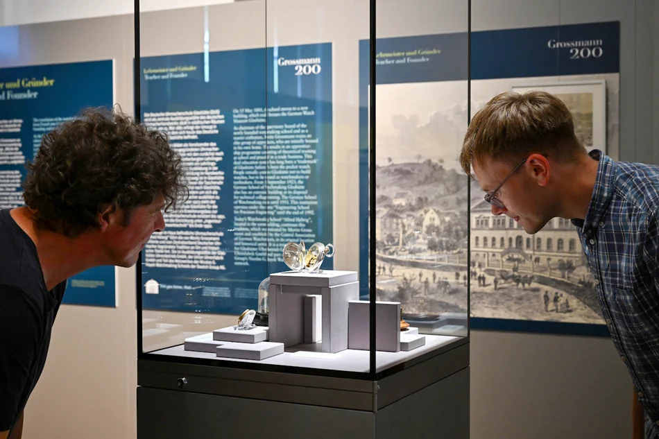 Gäste betrachten die aktuelle Sonderausstellung Gäste betrachten Uhren in einer Vitrine der aktuellen Sonderausstellung Grossmann200