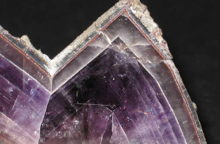 Glatt geschliffener Amethyst mit violetten, weißen und durchsichtigen Strukturen.