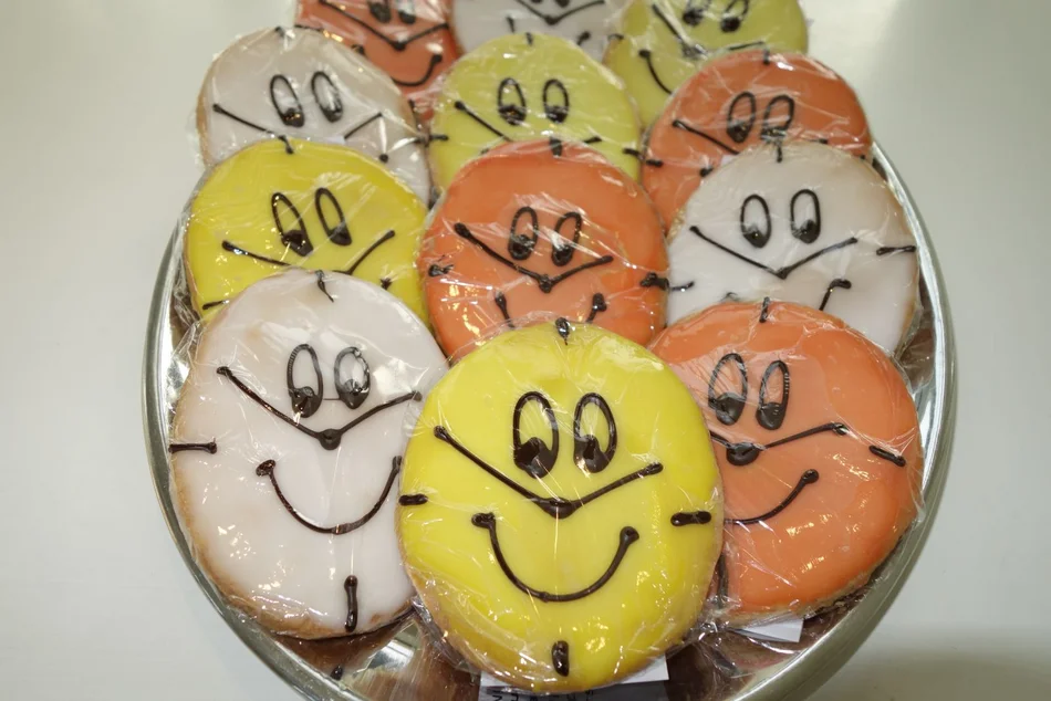 Uhrenkekse fürs Osterrätsel Kekse in Form von Ostereiern in Gelb, Orange und Weiß mit lachenden Uhrengesichtern