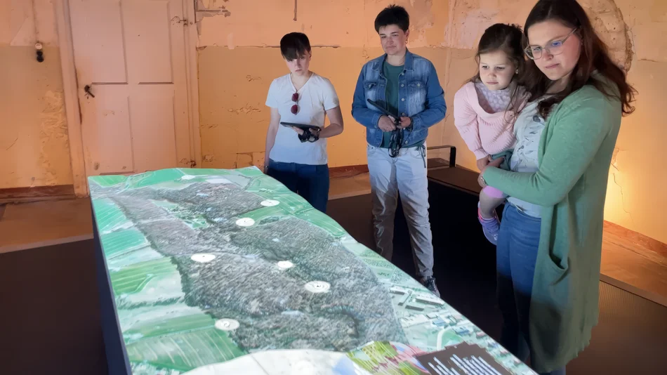 Eine Familie schaut sich die interaktive Karte des Colditzer Tiergartens an.