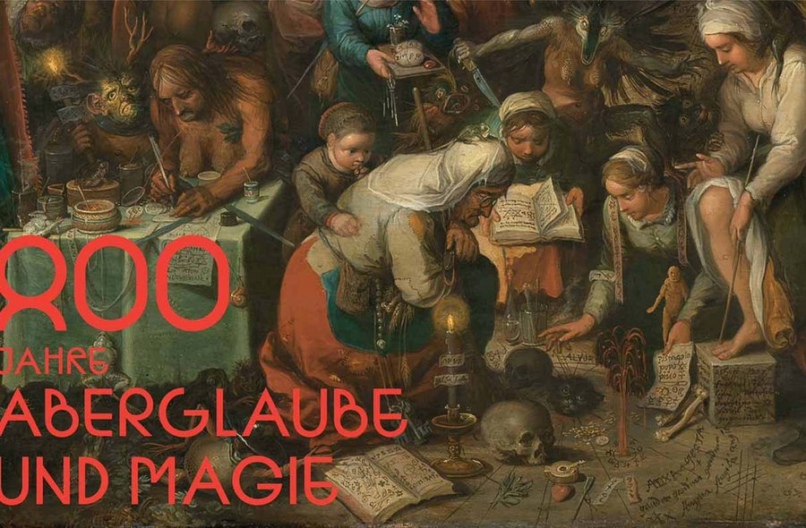Das Plakat zeigt den Titel "800 Jahre Aberglaube und Magie" in roter Schrift vor einem historischen Gemälde, auf dem mehrere Personen in einer Szene mit Büchern, Kerzen und rituellen Gegenständen dargestellt sind.