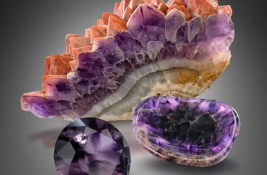 Eine mehrfarbige Amethyst-Stufe und zwei geschliffene, violette Amethyste sind nebeneinander liegend gruppiert.