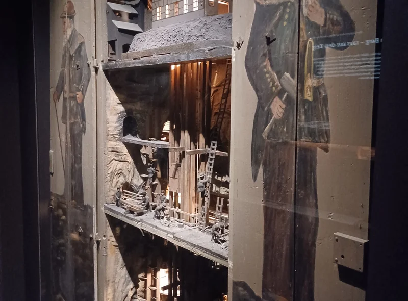 Modell eines historischen Bergwerks in einer Vitrine. Mehrere Ebenen mit Figuren sind sichtbar.