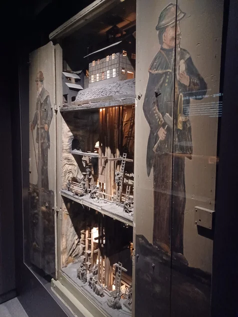 Modell eines historischen Bergwerks in einer Vitrine. Mehrere Ebenen mit Figuren sind sichtbar.