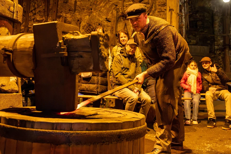 Tag des traditionellen Handwerks im Frohnauer Hammer Vor einer Besuchergruppe führt ein Mann im historischen Frohnauer Hammer das Schmieden vor.