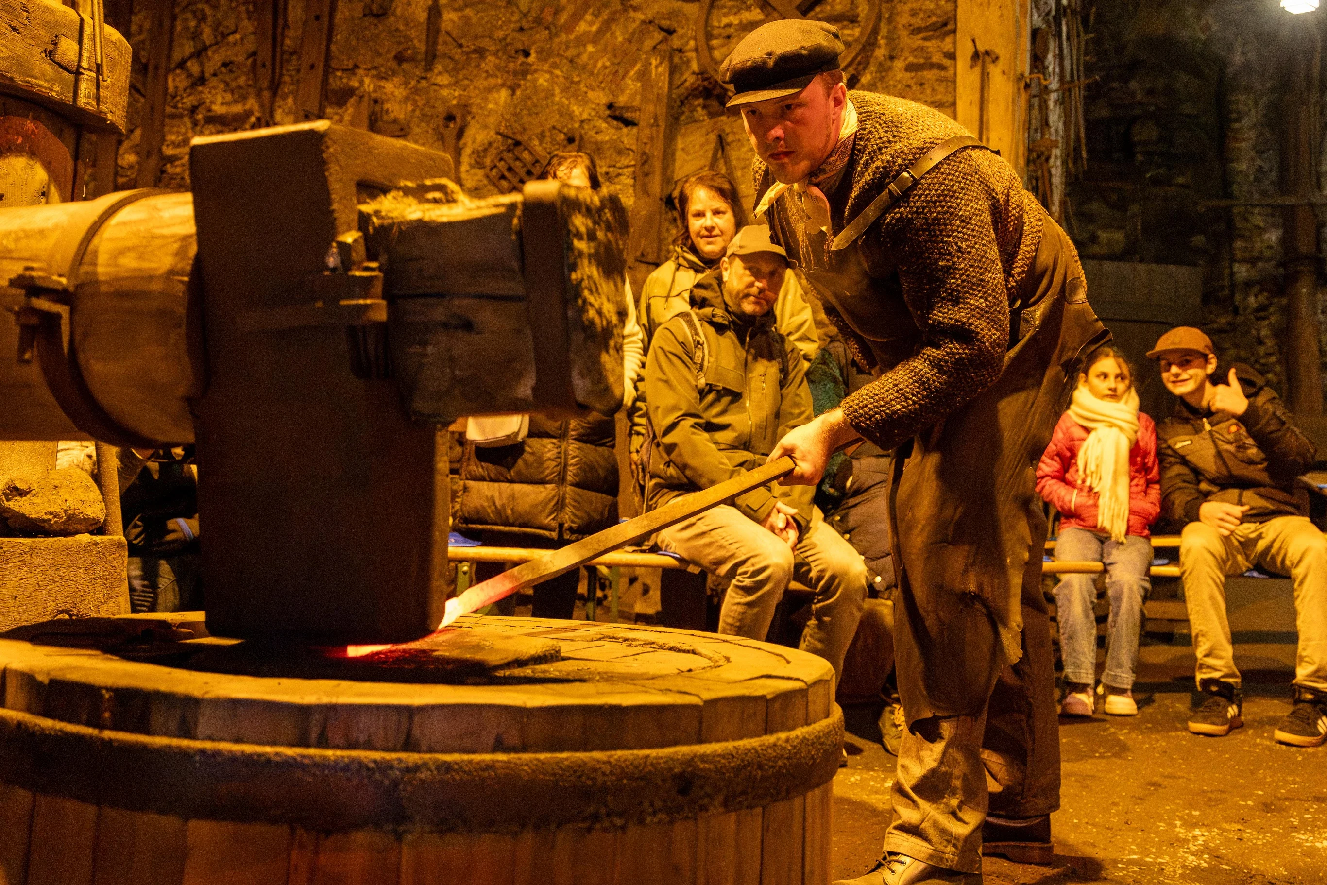 Tag des traditionellen Handwerks im Frohnauer Hammer Vor einer Besuchergruppe führt ein Mann im historischen Frohnauer Hammer das Schmieden vor.