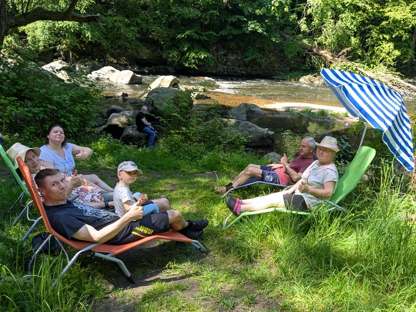 Eine Familie liegt auf Sonnenliegen am Fluss Chemnitz im Schweizerthal.