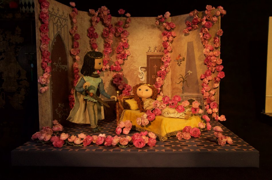 Eine Puppentheaterszene, in der in einem Gemach die Marionette des Prinzen neben der Marionette des Dornröschen steht