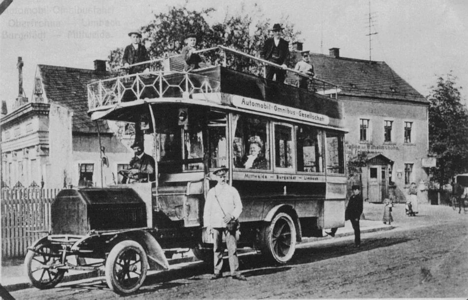 Omnibus 1906 Historisches Schwarzweißfoto eines an einer Haltestelle stehenden, mit Personen besetzten Busses
