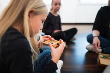Kinder entdecken Uhrenteile Kinder betrachten ein kleines Kästchen mit gebläuten Schrauben aus einer Armbanduhr
