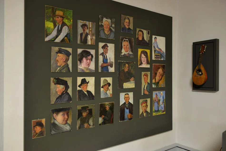 Ausstellungswand mit Porträts Bauern und Arbeitern aus vergangenen Zeiten