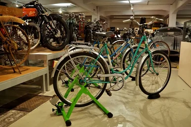 Das Fahrradkino im Fahrzeugmuseum In einem Zweirad-Ausstellungsraum stehen mehrere Fahrräder in den grünen Stationen des Fahrradkinos Chemnitz.
