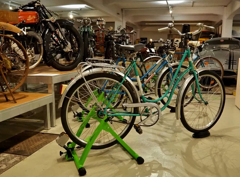 In einem Zweirad-Ausstellungsraum stehen mehrere Fahrräder in den grünen Stationen des Fahrradkinos Chemnitz.