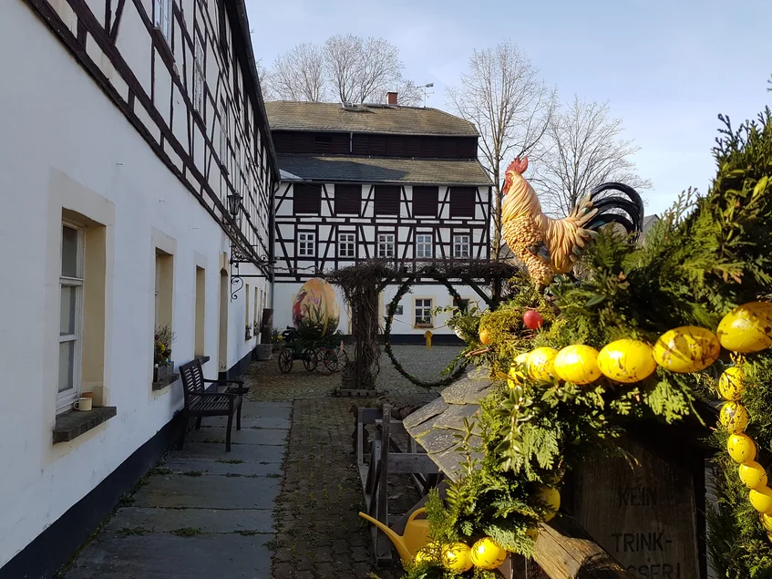 Ostern im Mühlenhof Geschmückter Osterbrunnen an der Papiermühle Niederzwönitz, einem großen historischen Fachwerkgebäude