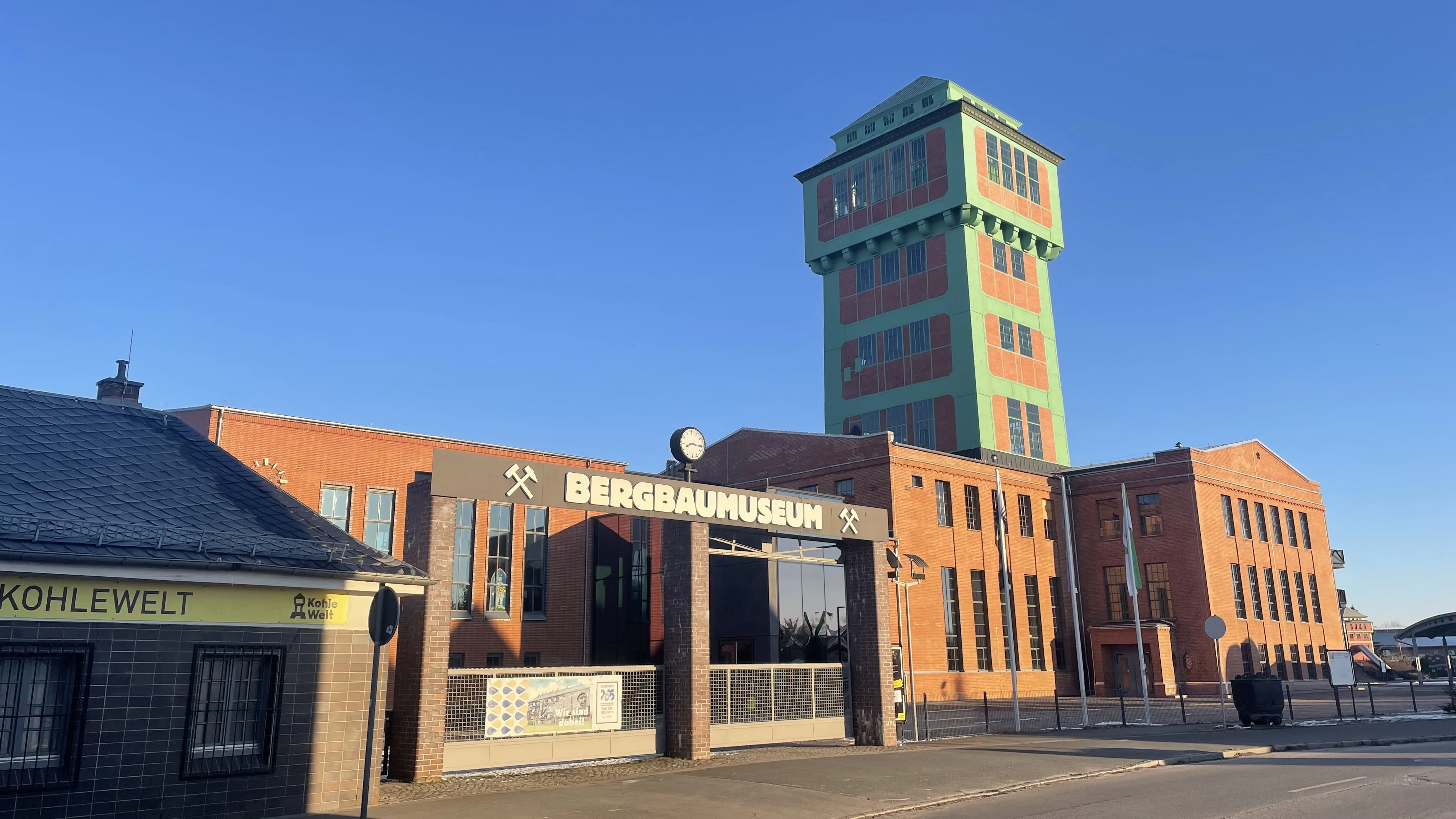 Historische Schachtanlage mit Förderturm und prägnantem Eingangstor. Über dem Tor steht "Bergbaumuseum".