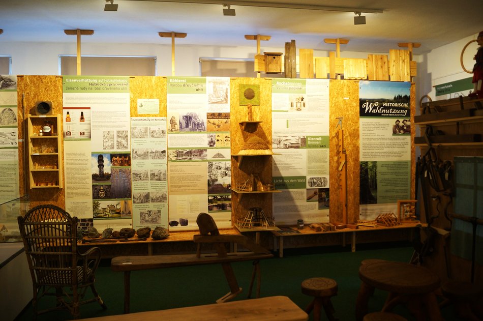 Blickfang ist eine lange Info-Wand mit Text- und Bildmaterial zur Waldnutzung früher und heute, davor befinden sich Exponate zum Anfassen sowie einige Sitzgelegenheiten.