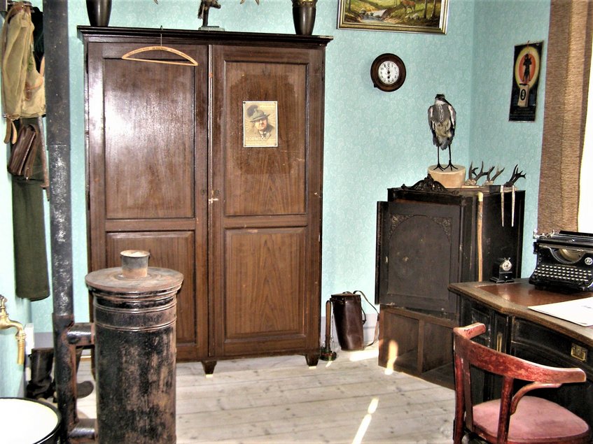 Inszenierung eines Försterbüros mit großem Holzschrank, Schreibtisch mit Schreibmaschine und weiterem historischen Mobiliar sowie Reh-Geweihen und einem ausgestopften Vogel