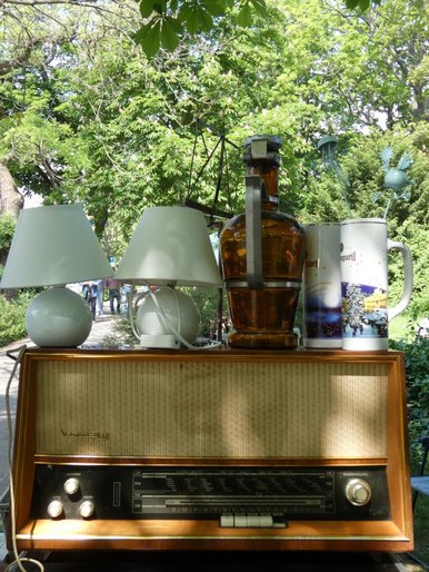 Trödelmarkt in Oschatz Auf einem alten "Weltempfänger"-Radio stehen zwei kleine weiße Nachttischlampen, eine braune Glasflasche und ein Porzellankrug.