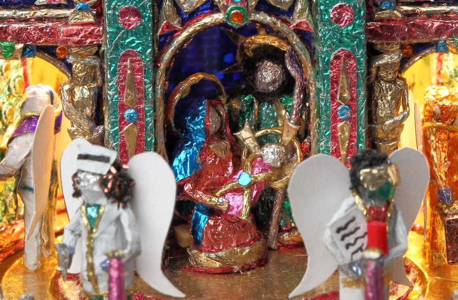 Farbenfrohe, aus verschiedenenfarbigen Folien gefertigte Krippe mit den Figuren von Maria mit dem Jesuskind auf dem Arm und mehreren um sie herum positionierten Engelsfiguren