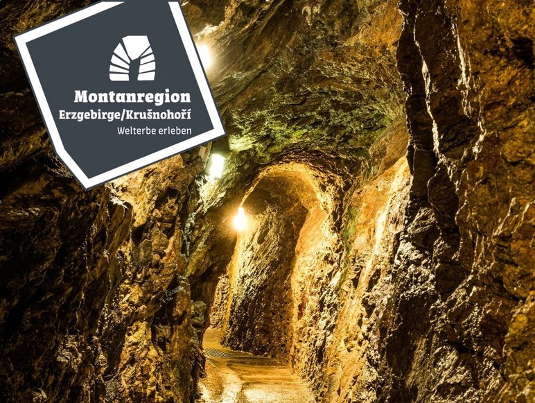 Das Foto zeigt einen beleuchteten Stollen im Besucherbergwerk „Im Gößner“, einem ehemaligen Silberbergwerk in der UNESCO-Welterbe Montanregion Erzgebirge/Krušnohoří.