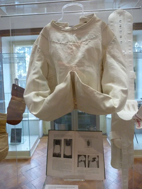 Vitrine mit Zwangsjacke
