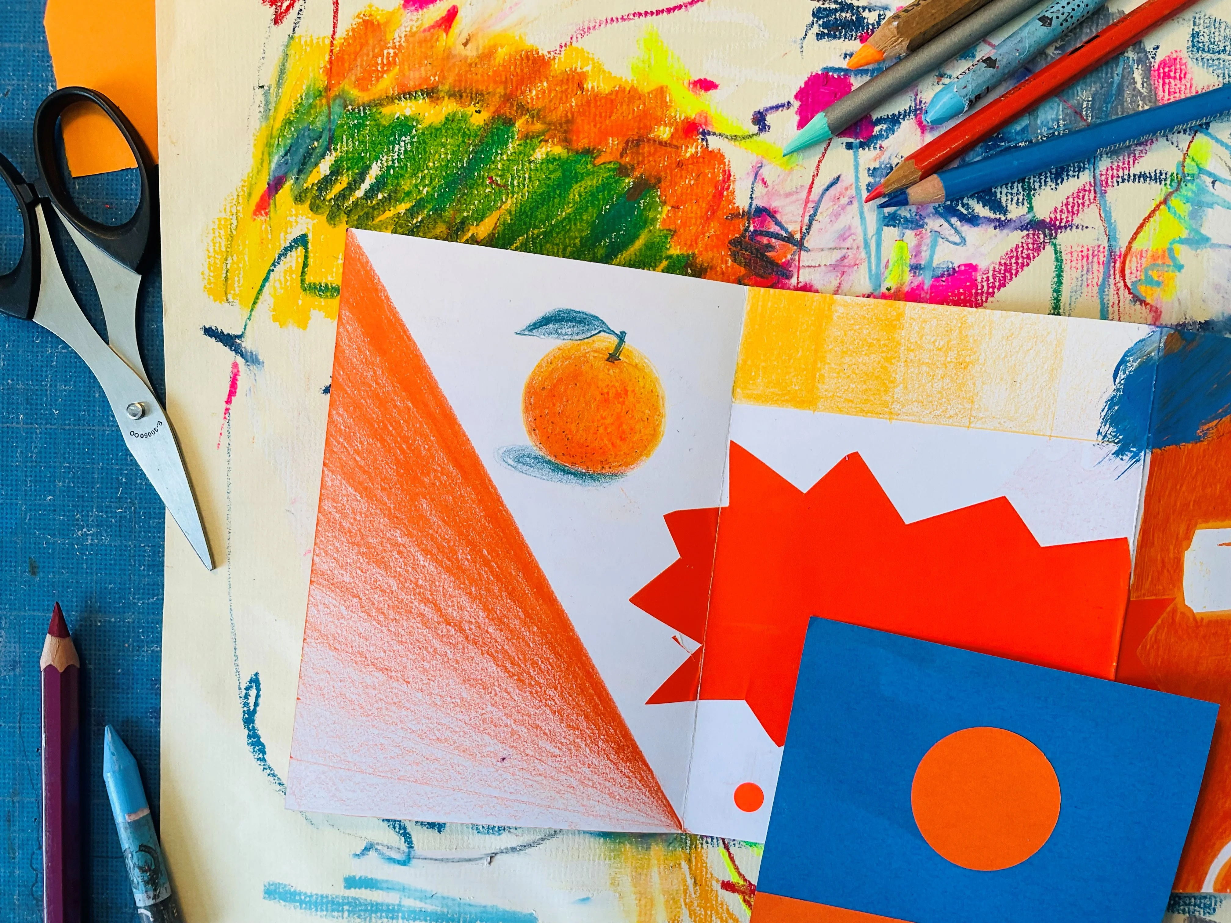 Neben mehreren bunt bemalten und bunt beklebten Papieren liegen Buntstifte und eine Schere.