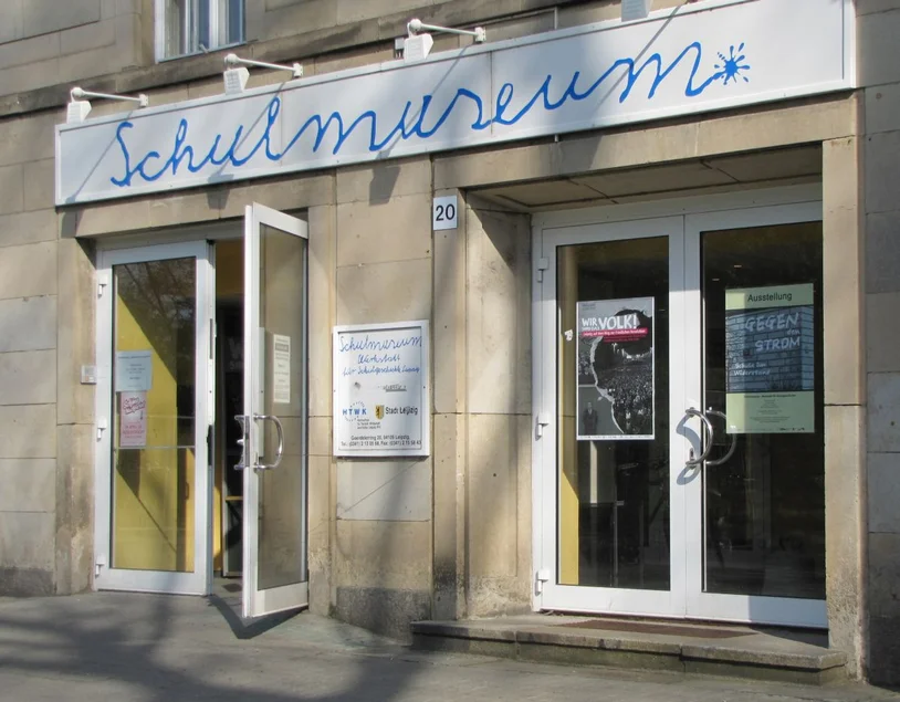 Eingangsbereich Foto des Eingangs zum Museum; über der Tür ist ein langes, weißes Schild, auf dem in Schreibschrift "Schulmuseum" steht