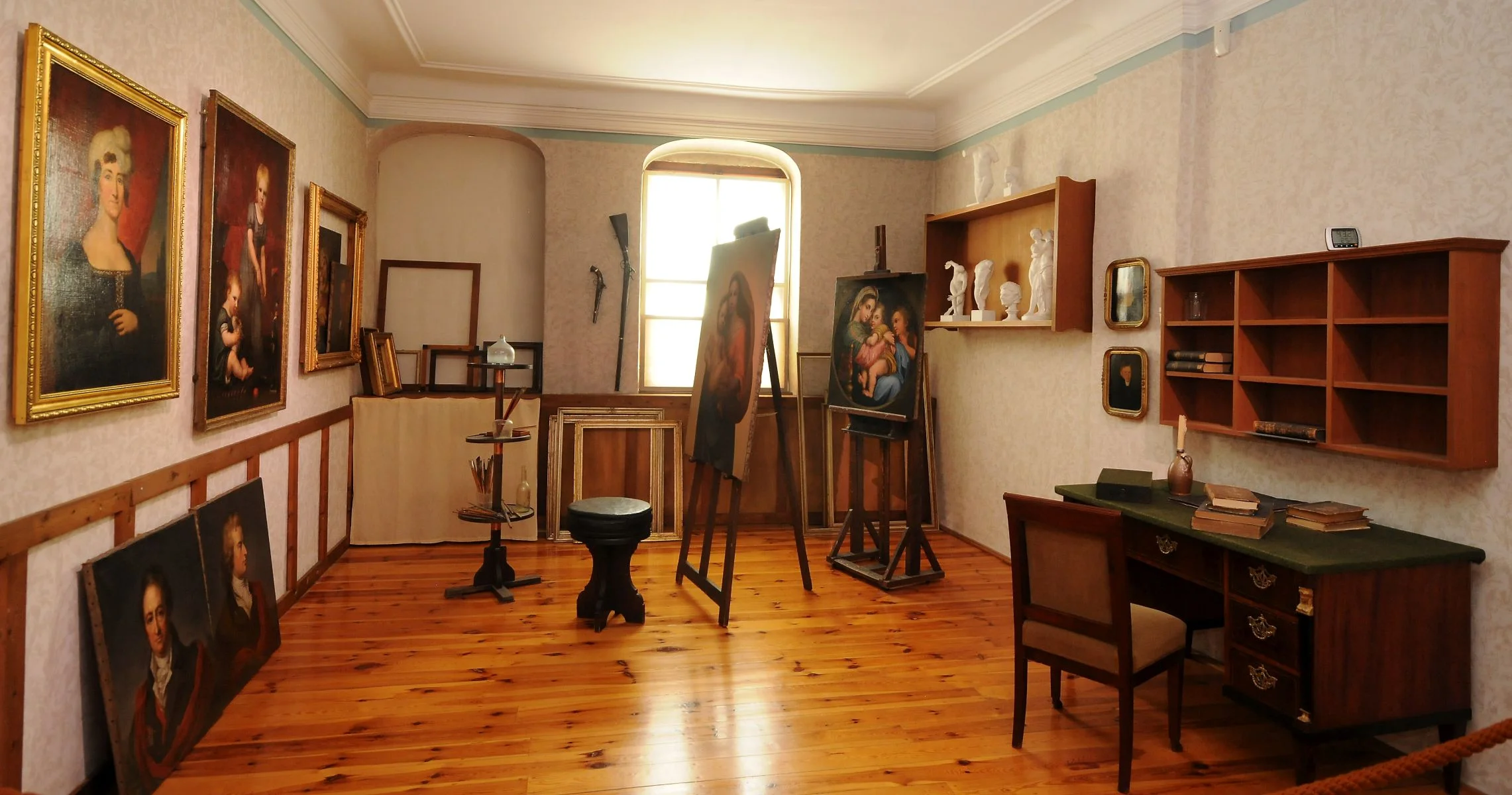 Ein wie ein historisches Künstleratelier anmutender Raum mit Gemälden, Staffeleien, Büchern und Skulpturen