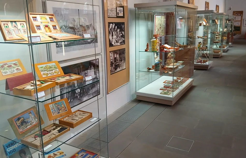 In mehreren Glasvitrinen sind die Holzbaukästen und weitere Spielzeuge thematisch zusammengestellt.