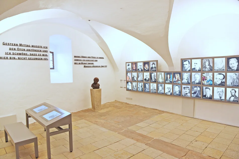 Medienstation und Fotowand der Inhaftieren Ausstellungssaal: Medienstation, Zitate an der Wand, eine Büste Johann Fridrich Böttgers und zahlreiche Bildnisse Gefangener