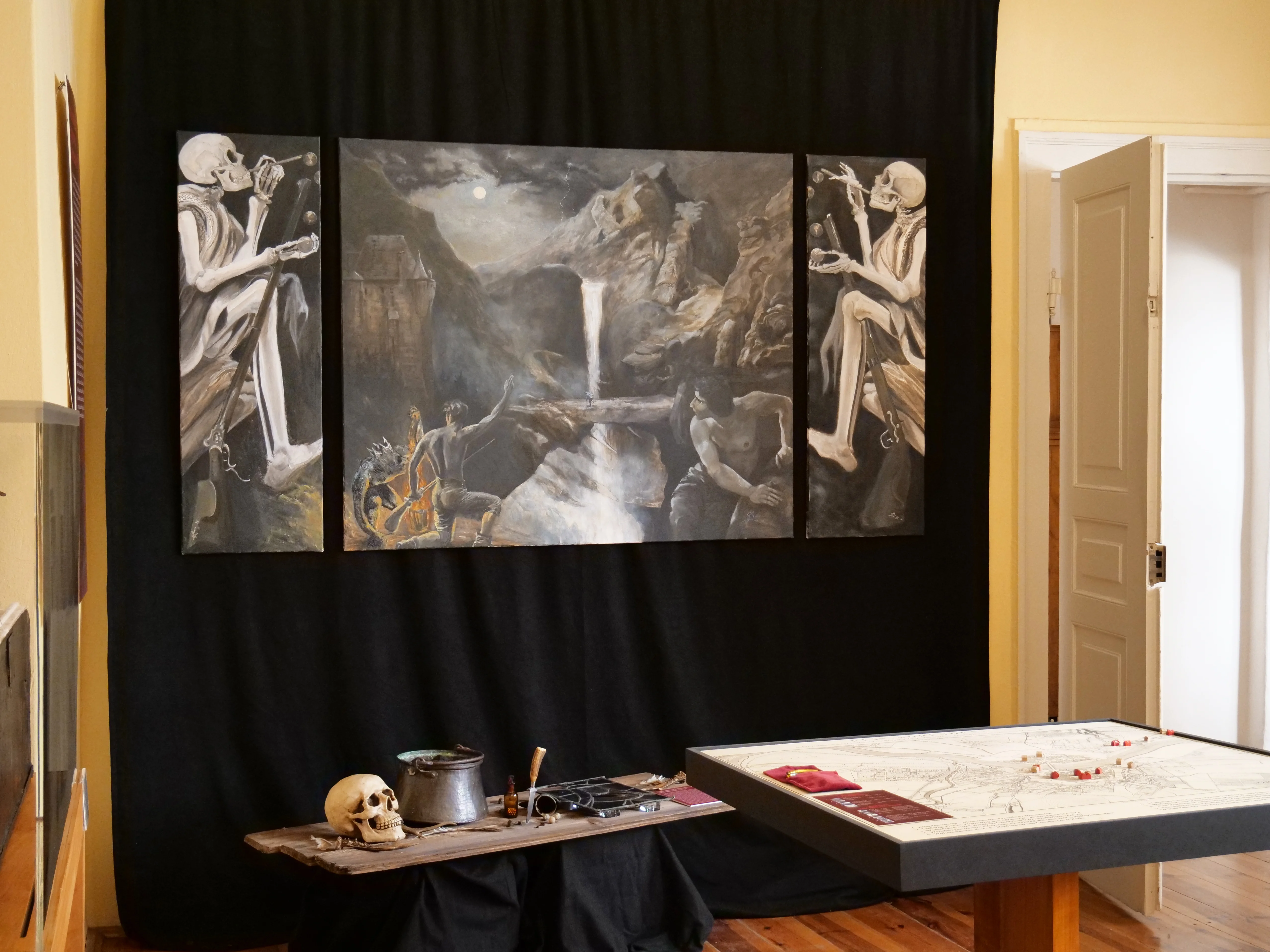 Ausstellungsraum mit Gemälde und verschiedenen Requisiten im Stile der Schauer-Romantik, mit Gerippen und Schädeln