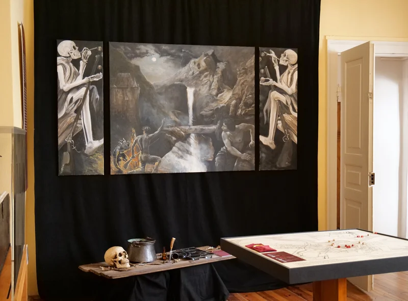 Ausstellungsraum mit Gemälde und verschiedenen Requisiten im Stile der Schauer-Romantik, mit Gerippen und Schädeln