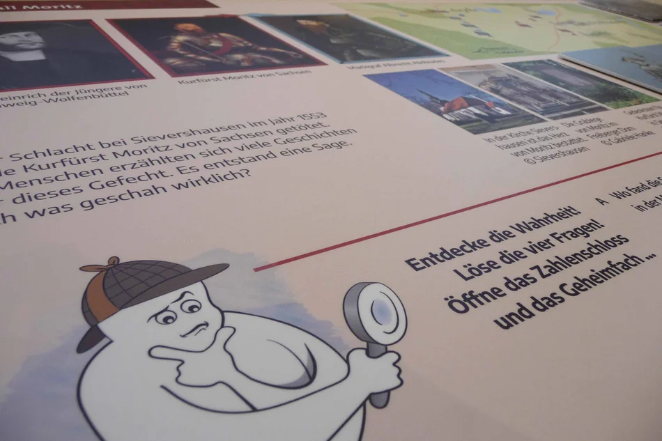 Der mysteriöse Mordfall um Kurfürst Moritz und Georg Karras Detailaufnahme einer museumspädagogischen Tafel, auf der Maskottchen Cosimir als Detektiv verkleidet eine Lupe in der Hand hält