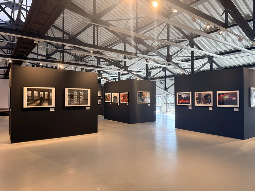 Blick in die Sonderausstellung „Kohlenstaub auf Polaroid. 40 Jahre Museum im Schacht“ Großer Raum mit schwarzen Ausstellungswänden, an denen großformatige Fotografien präsentiert werden