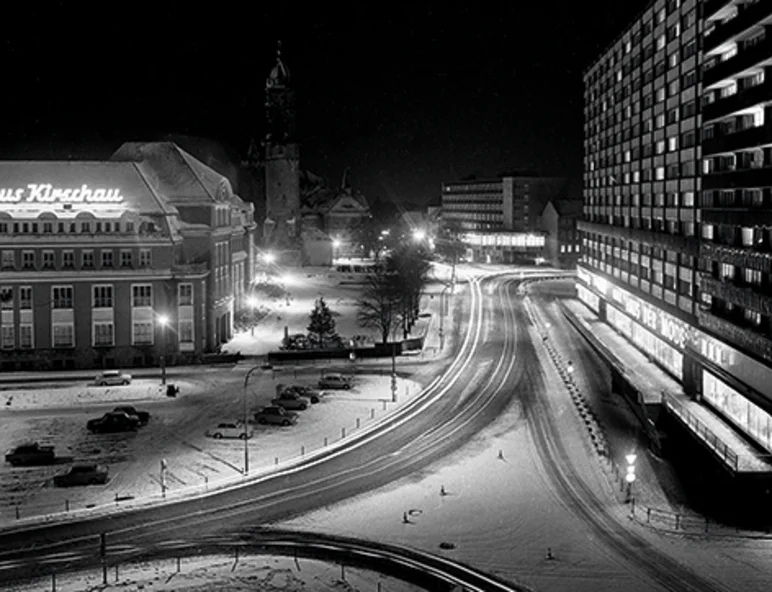 Verschneite Straßenkreuzung bei Nacht. Links Museum Bautzen, rechts Hochhausblock, im Hintergrund historischer Reichenturm.