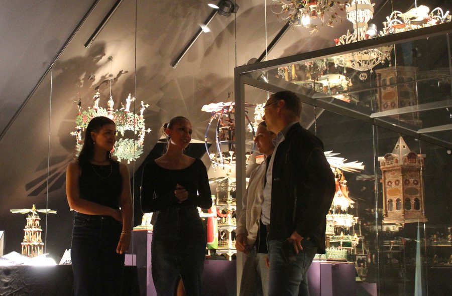 Annaberg-Buchholzer Museumsnacht Vier Personen stehen in einem Ausstellungsraum, in dem eine Vielzahl erzgebirgischer Weihnachtspyramiden und andere Schnitzkunst präsentiert werden.