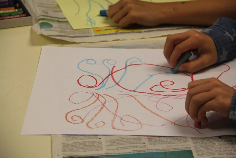 Das Foto zeigt die Hände zweier Personen, die Hörbilder nach Musik zeichnen.