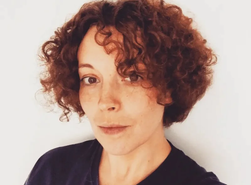 Porträtfoto von Katerina Kuznetsova, einer Frau mit lockigen dunklen Haaren, die hier den Betrachtenden direkt anblickt