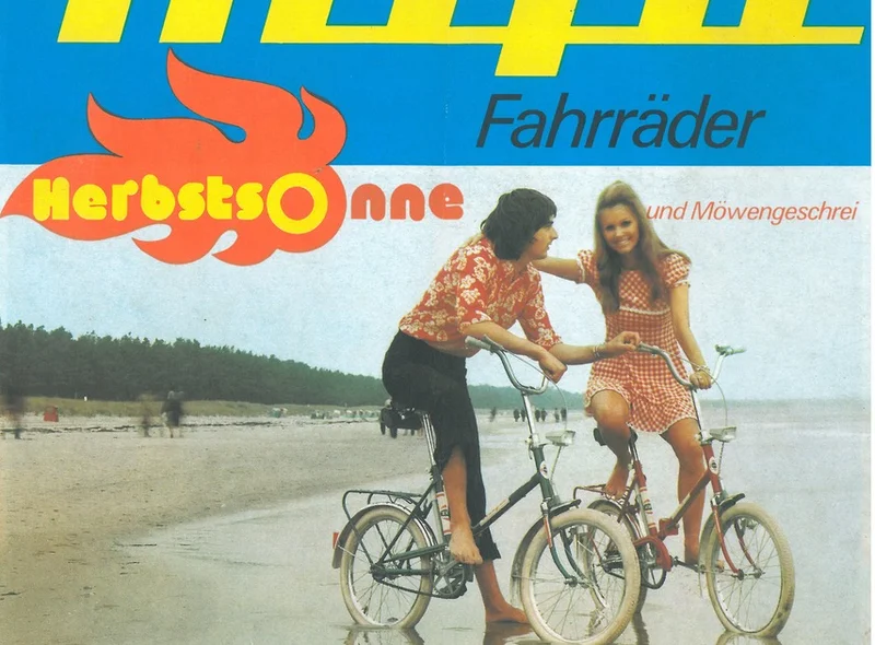 Werbemotiv aus den 1970er Jahren: Ein Mann und eine Frau auf Klappfahrrädern der DDR-Marke Mifa am Ostsee-Strand