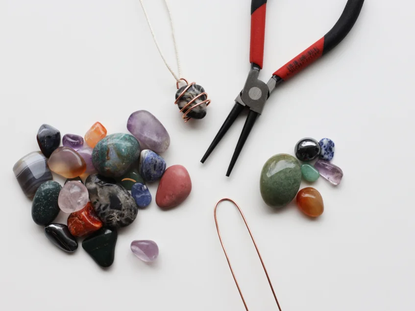 Das Bild zeigt ein Werkzeug neben Edelsteinen.