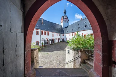 offenes Burgtor, Burghof mit Turm im Hintergrund, sommerliches Wetter