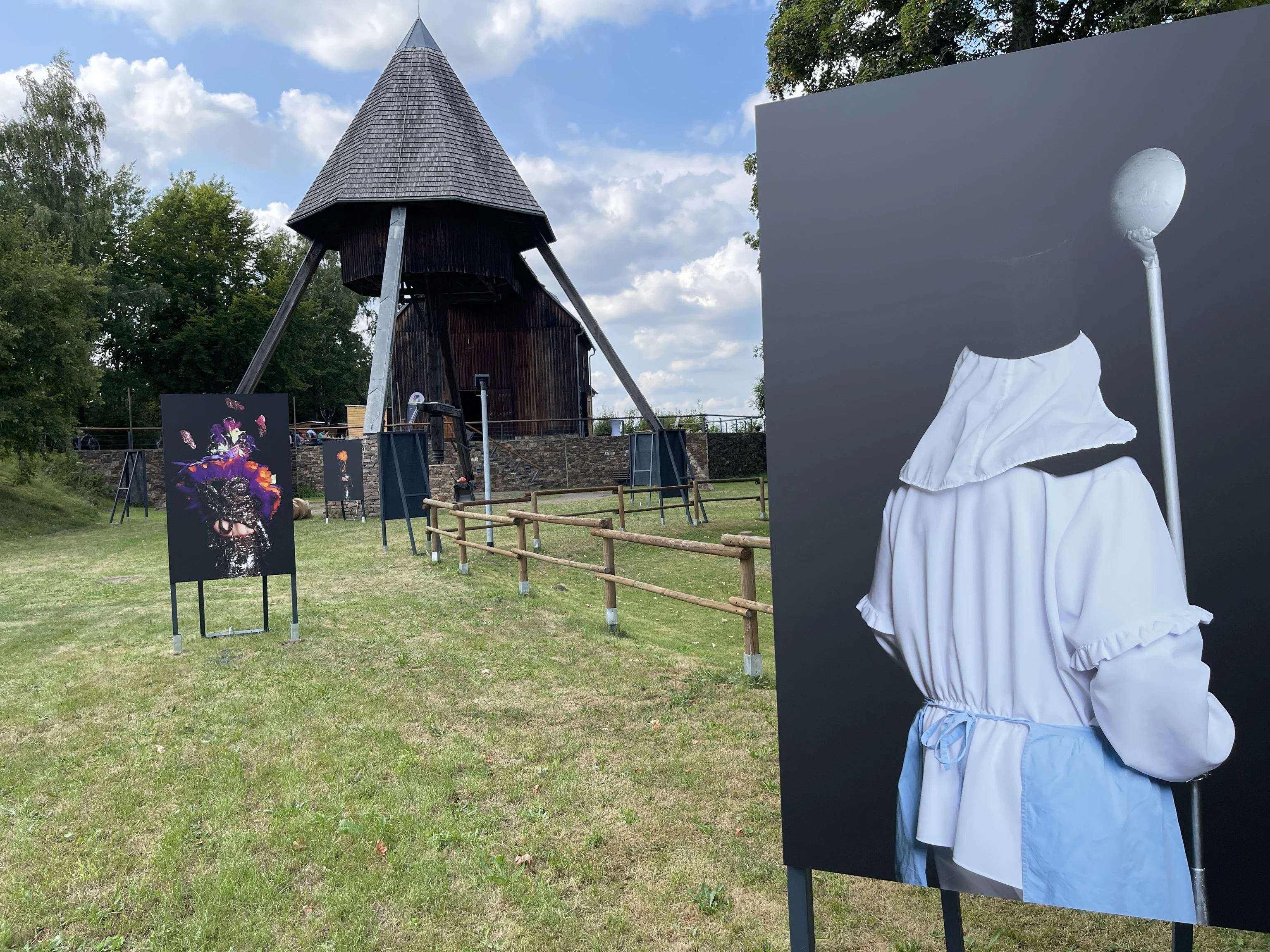 Fotokunst der Düsseldorferin Corina Gertz im erzgebirgischen Lauta Vor dem Pferdegöpel auf dem Rudolphschacht stehen große Tafeln mit Fotografien von Bergmännern in traditionellem Habit.