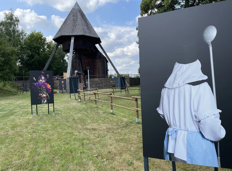 Vor dem Pferdegöpel auf dem Rudolphschacht stehen große Tafeln mit Fotografien von Bergmännern in traditionellem Habit.