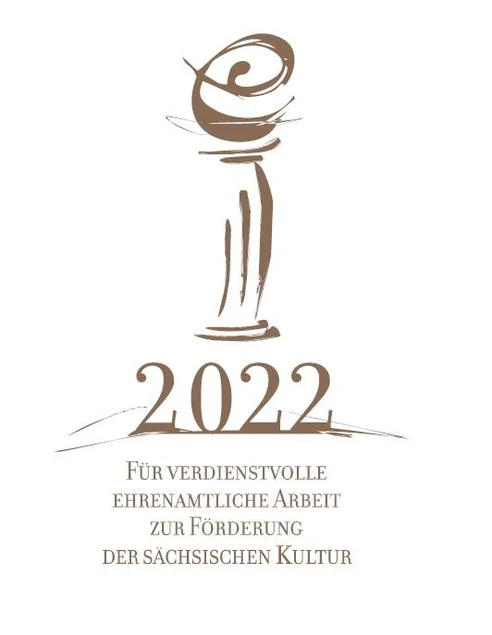 Logo der Auszeichnung „Ehrenamt in der Kultur 2022“ Das Foto zeigt das Logo der Auszeichnung für verdienstvolle ehrenamtliche Arbeit zur Förderung der sächsischen Kultur 2022. Es enthält eine von einem kleinen, geschwungenen „e“ gekrönte, stilisierte klassizistische Säule.