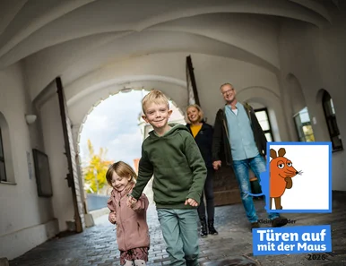 Am 3. Oktober heißt es wieder „Türen auf mit der Maus“ Ein Junge (ca. 7) und ein Mädchen (ca. 5 Jahre) rennen lachend durch den Torbogen in den Innenhof von Schloss Hartenfels.