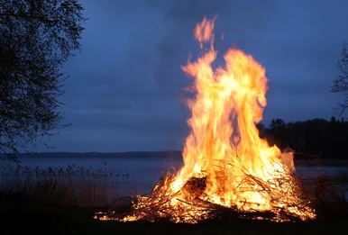 Feuer machen wie in der Steinzeit! Im Dunkeln brennt ein Lagerfeuer.