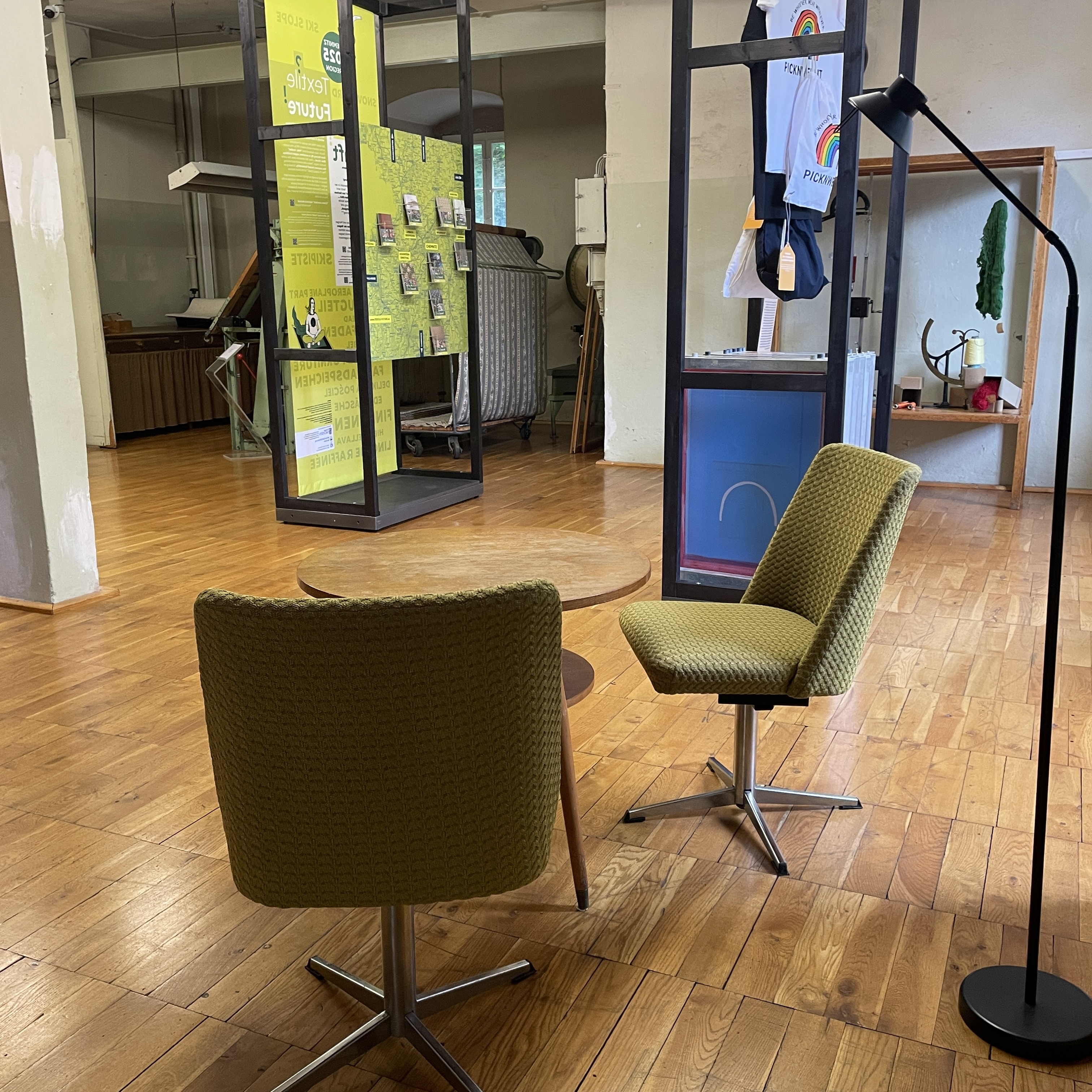 Ausstellungsraum mit textil-gepolsterten Drehsesseln und im Hintergrund Ausstellungs-Schauwänden