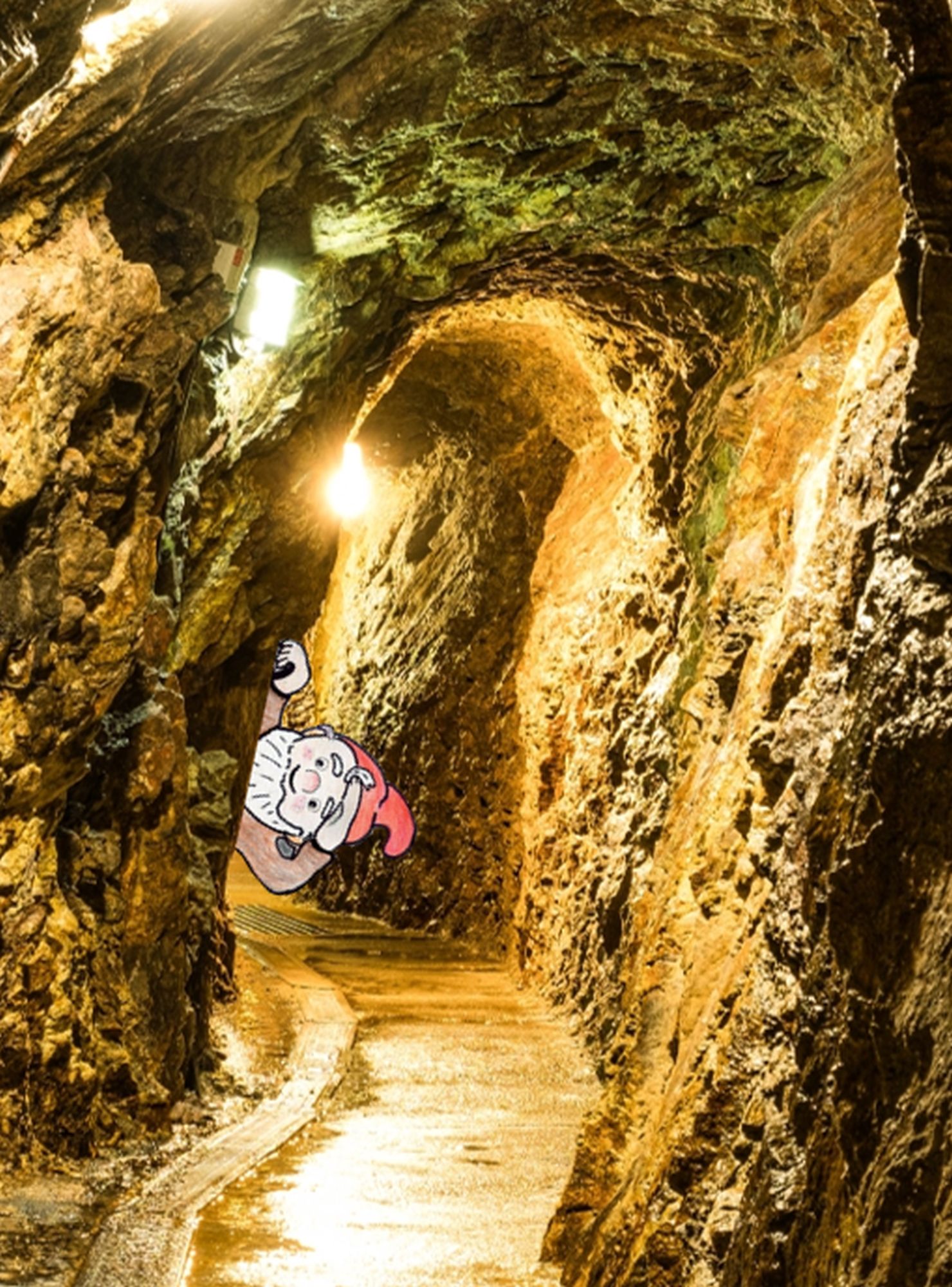 Foto eines beleuchteten Bergwerkstollens, in das eine cartoonhafte Zeichnung eines frechen Zwerges eingefügt ist